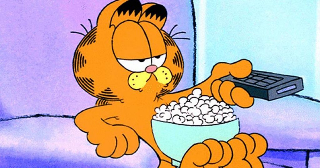 Garfield the cat on sofa with popcorn and remote