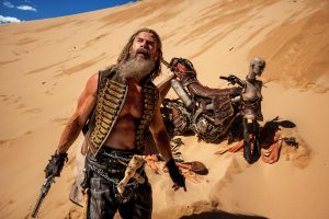 chris hemsworth in desert as dementus, still from furiosa: a mad max saga by george miller