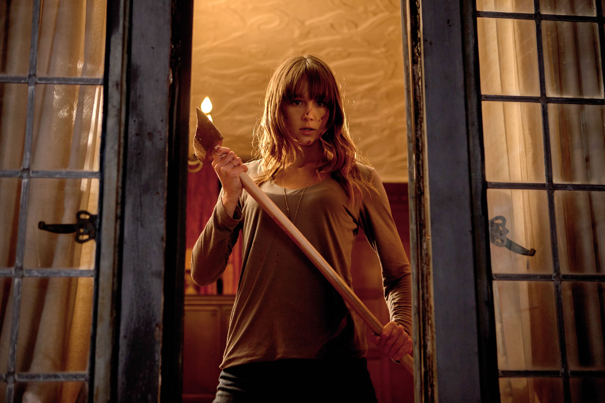 Woman holding axe in window