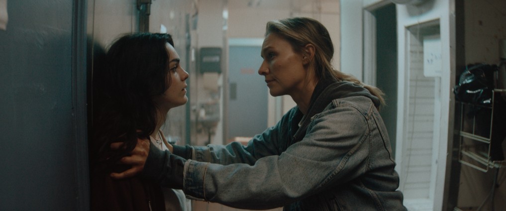 Promotional shot from the 2026 film Redux Redux showing the lead characters Irene and Mia clashing